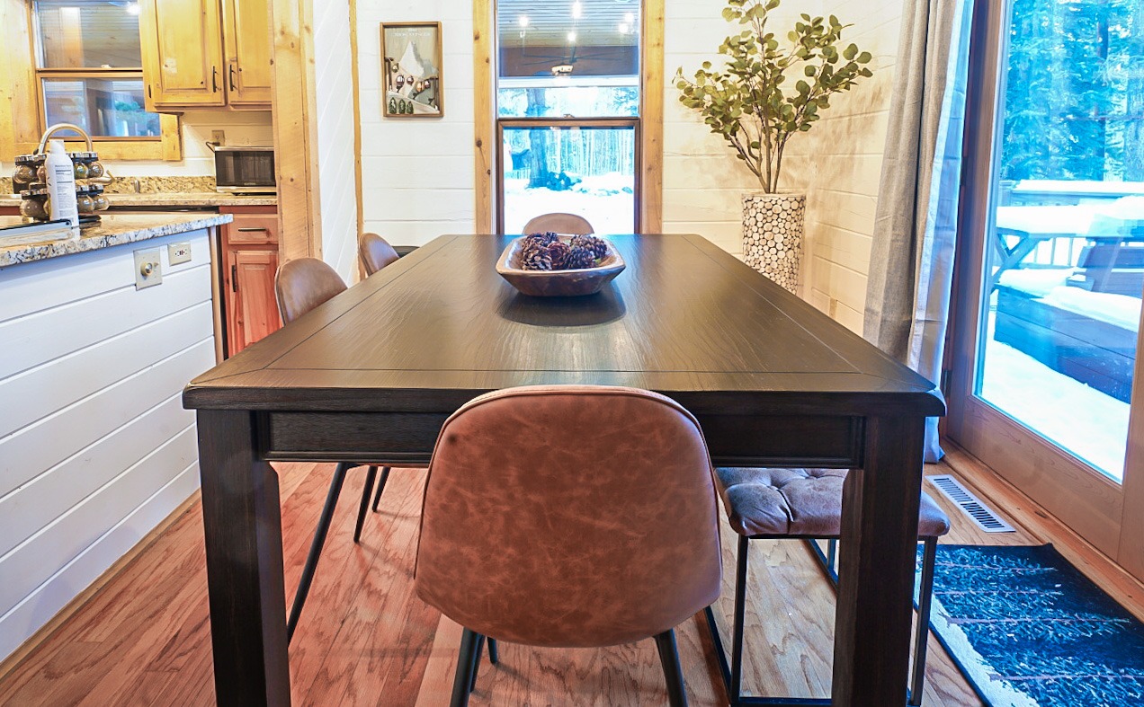 Dining table set with leather chairs and a bench beside the sliding door