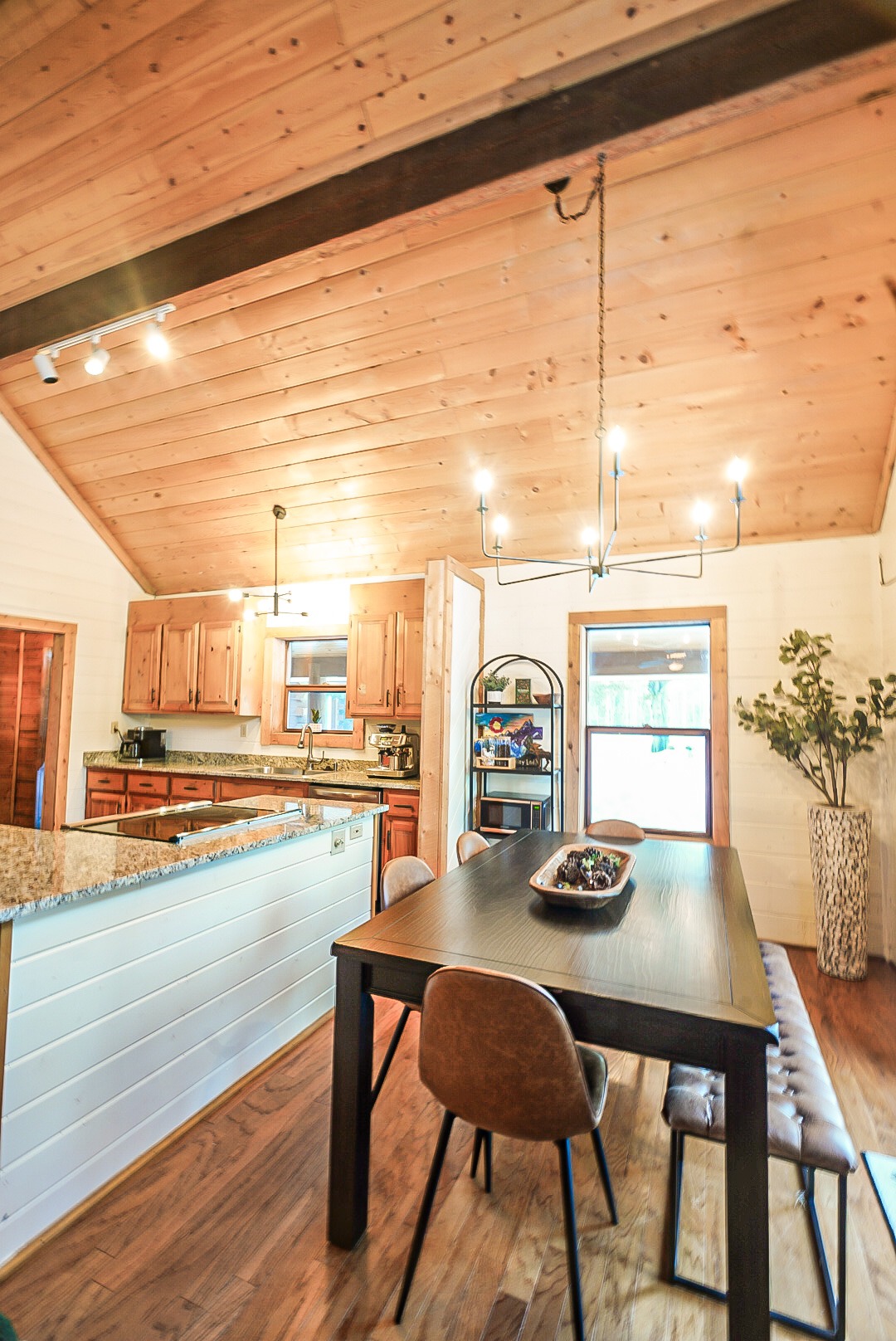 Dining table under the vaulted pine ceiling beside the kitchen