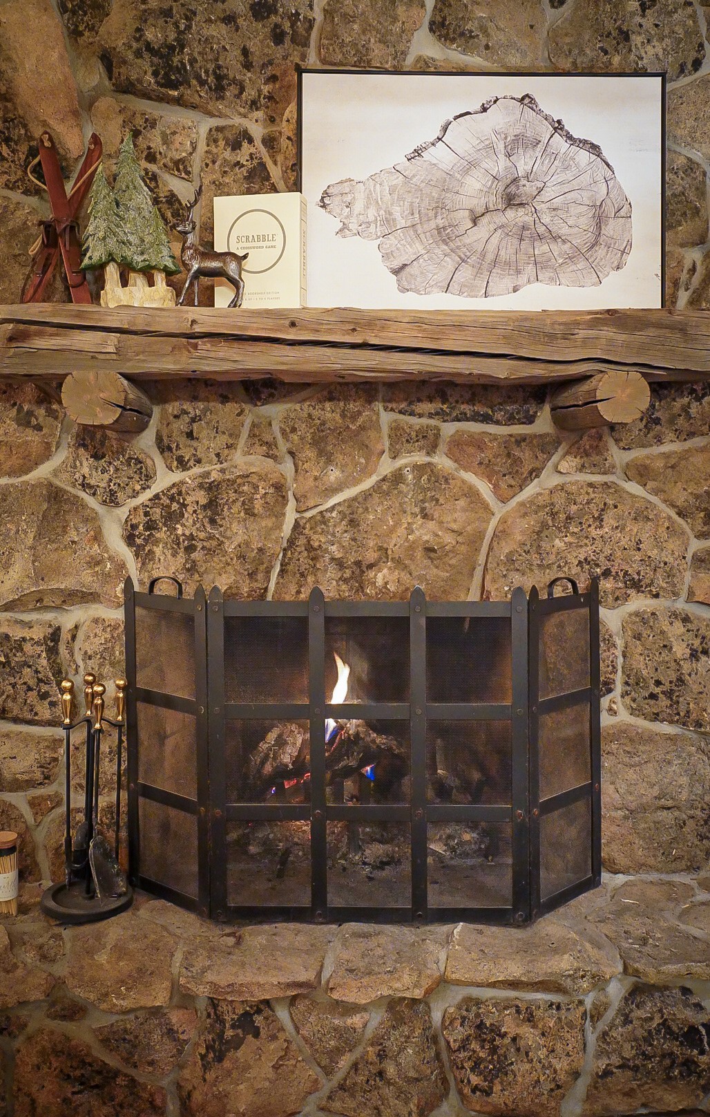 Fire burning in the moss-rock fireplace beside a sheepskin stool