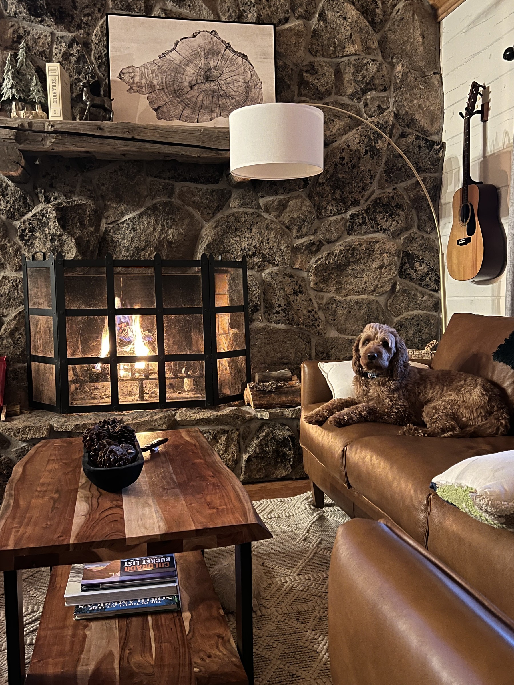 Leather sofas gathered around the stone fireplace in the evening