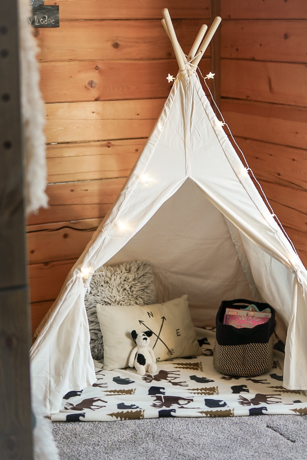 Kids' teepee play tent with string lights, pillows and toys