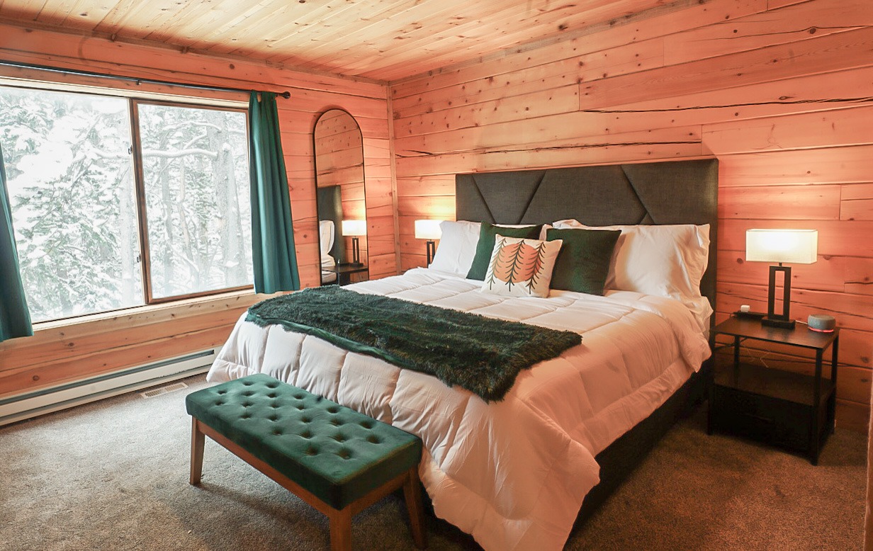Second king bedroom with a green velvet bench at the foot of the bed