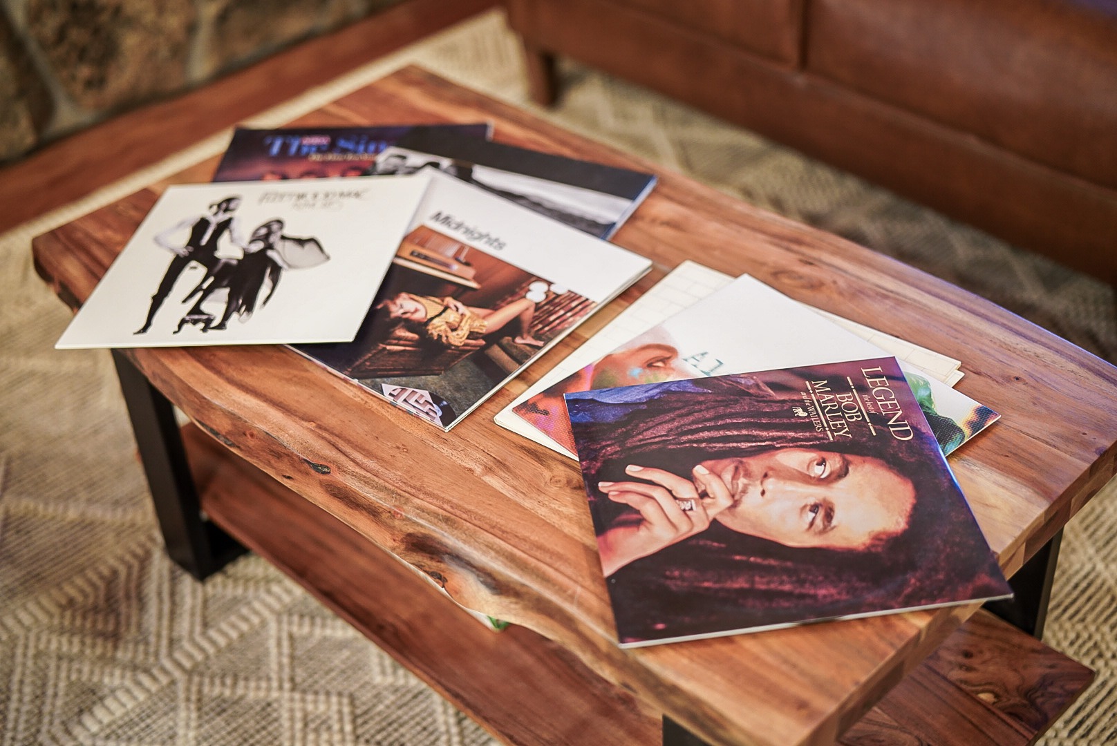 Vinyl records spread across the live-edge coffee table